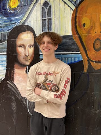 Gage Messerli stands in front of one of the PCM High School murals!
