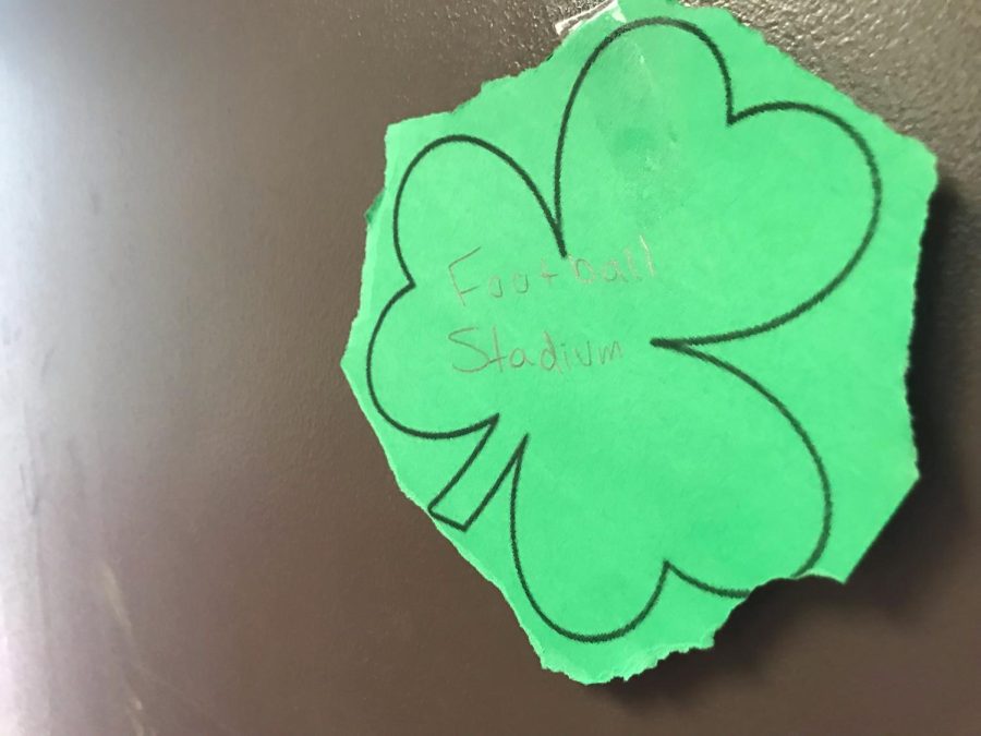 A shamrock found by the boys locker room. It reads football stadium because it is on the door leading to the football stadium. 