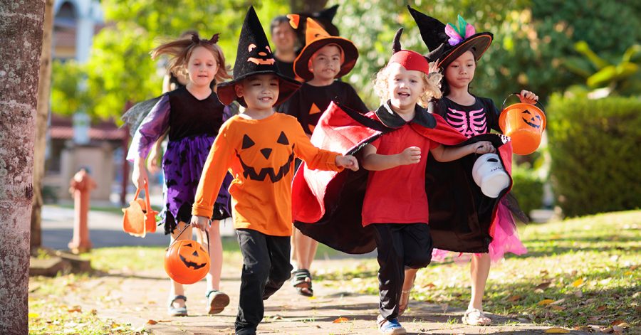 Child+in+Halloween+costume.+Mixed+race+Asian+and+Caucasian+kids+and+parents+trick+or+treat+on+street.+Little+boy+and+girl+with+pumpkin+lantern+and+candy+bucket.+Baby+in+witch+hat.+Autumn+holiday+fun.