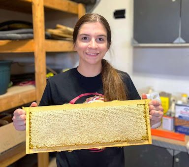 Reed poses with one of her many honeycomb harvests from this year. Despite losing bees, the quality of honey has remained excellent. 