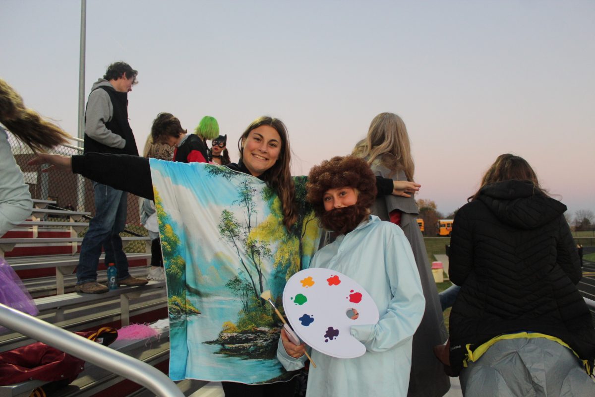 Jorja Teeter and Kyra Naeve dressed as Bob Ross and his painting for the game