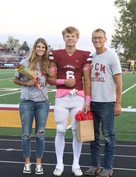 Senior football player Riley Graber walking down the track with his parents last Friday.
