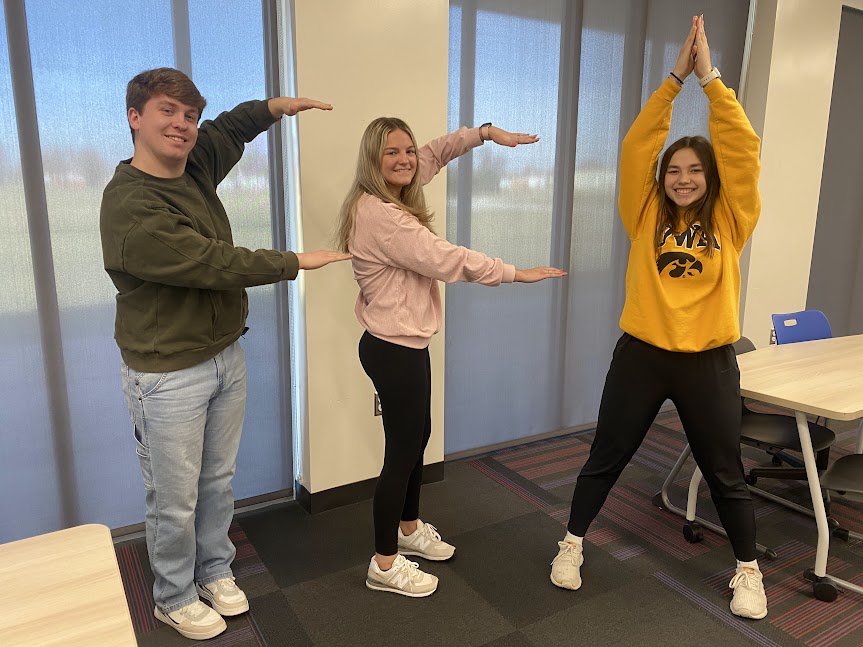 FFA members Carter Dudley, Gretchen Uitermarkt, and Seriah Nolin pose to spell out, "FFA."